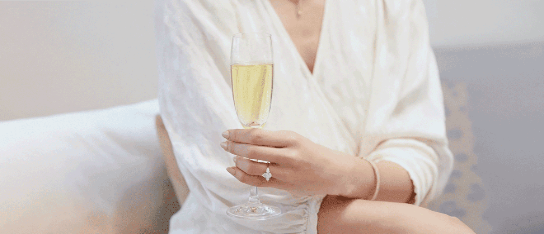 Woman Wearing a Bespoke Diamond Engagement Ring Holding a Champagne Flute for Mark Solomon Jewellers in Cape Town.