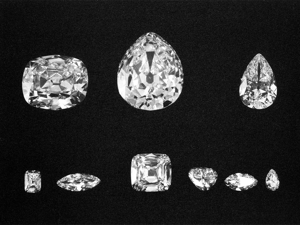 Several Cut Diamonds of Varying Shapes and Sizes Displayed on a Black Background, from Small to Large.