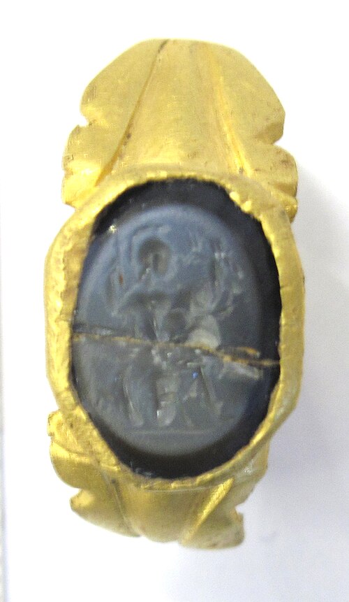 Gold Ring with an Oval Dark Gray Cameo Depicting a Carved Profile Facing Left.