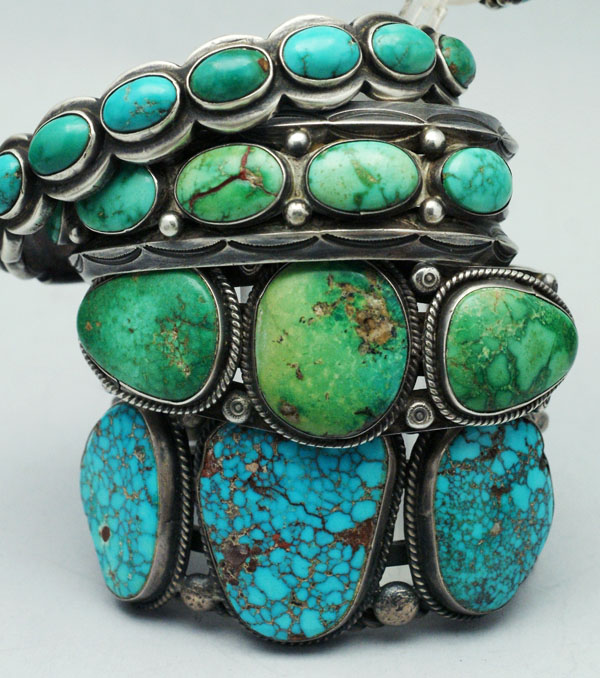 Stacked Silver Bracelets with Turquoise Stones in Varying Blue-green Hues, Close-up Detail of the Jewelry.