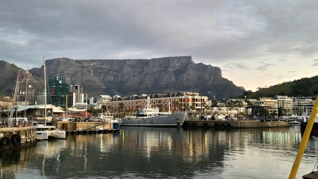 Nico-smit-0o2pqflrdei-unsplash - Mark Solomon Jewellers Harbor with Boats Docked Along a Quay, Colorful Buildings at the Water’s Edge, and Table Mountain in the Background Under a Cloudy Sky.