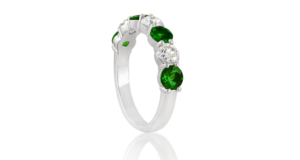 Perspective view of rare tsavorite green gemstone and diamond eternity ring handcrafted and set in white gold