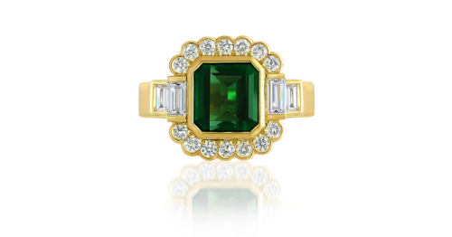 This art-deco inspired Tourmaline and Baguette Diamond Ring heralds a vivid green tourmaline gemstone (chrome tourmaline totalling 2.70ct with EGL Certification), shouldered by 4 baguette-cut diamonds (baguette-cut diamonds totalling: 0.38ct, F-G colour), with a partial halo of 14 glittering round brilliant cut diamonds (round brilliant diamonds totalling: 0.29ct, VS clarity). Handcrafted by our Master Goldsmiths on our premises using the highest grade 18ct yellow gold.