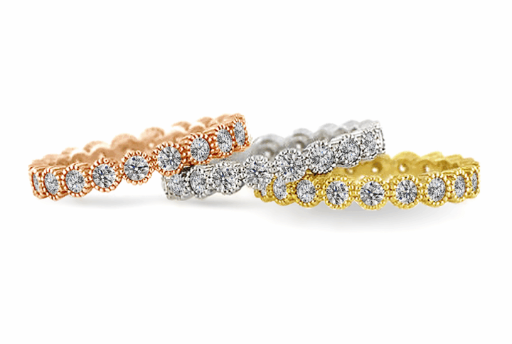 Three Eternity Bands in Rose Gold, White Gold, and Yellow Gold with Scalloped Settings and Claw-set Diamonds.