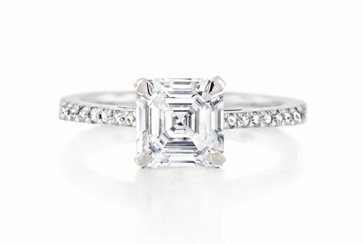 a Classic Asscher-cut Solitaire Diamond Engagement Ring. the Large Step-cut Diamond is Held by Four Claws and Set on a Delicate Band Adorned with Pave-set Diamonds in White Gold or Platinum.