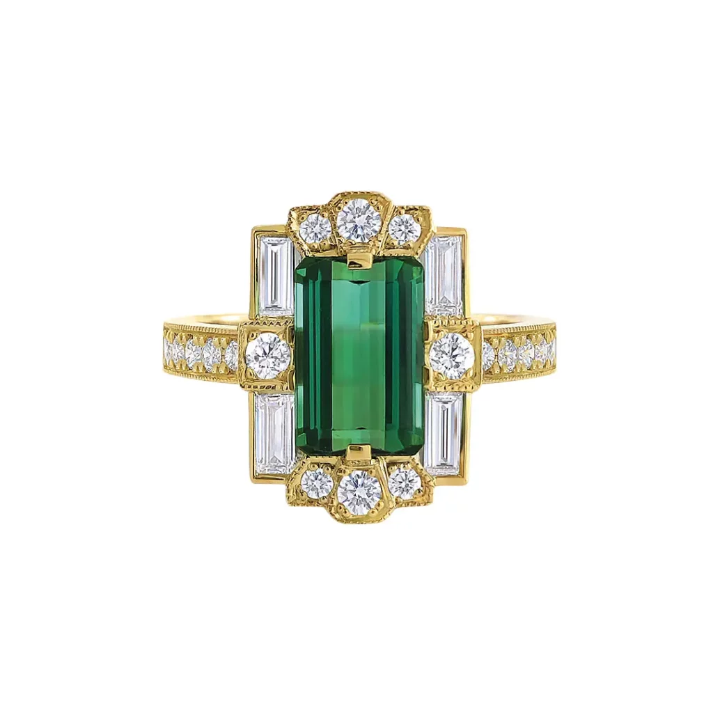 a Vintage-inspired Art Deco Ring Featuring a Rectangular Emerald-cut Green Tourmaline Center Stone. the Tourmaline is Flanked by Baguette and Round Diamonds, with a Yellow Gold Band Adorned with Pave Diamonds and Milgrain Detailing.