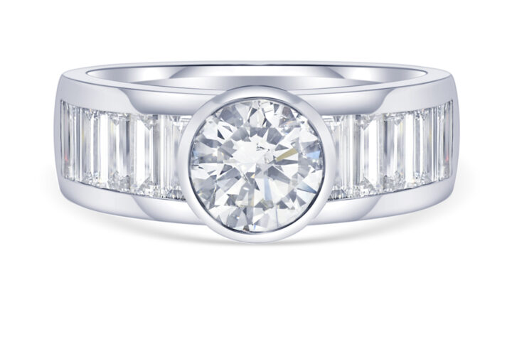 a Modern Ring Featuring a Round Brilliant Cut Diamond Set in a Bezel Setting. the Band is Channel-set with Baguette-cut Diamonds in White Gold or Platinum.