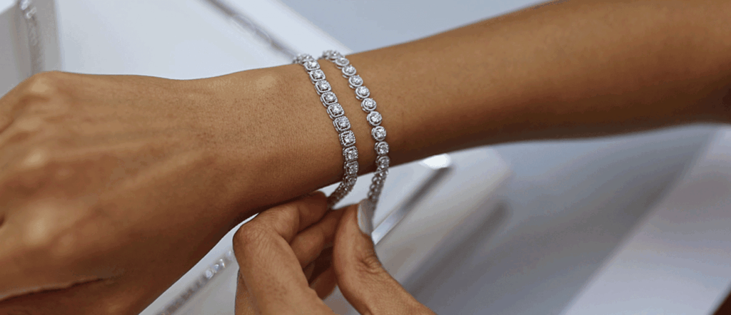 Diamond Tennis Bracelets | Mark Solomon Jewellers Trending Collections - Mark Solomon Jewellers a Woman Trying on Two Diamond Tennis Bracelets in a Jewellery Boutique, Showcasing the Sparkle and Detail of Mark Solomon Jewellers’ Tennis Bracelet Collection.